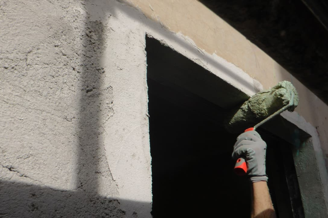 Roller applying Aquabond in preparation for Diathonite Plaster