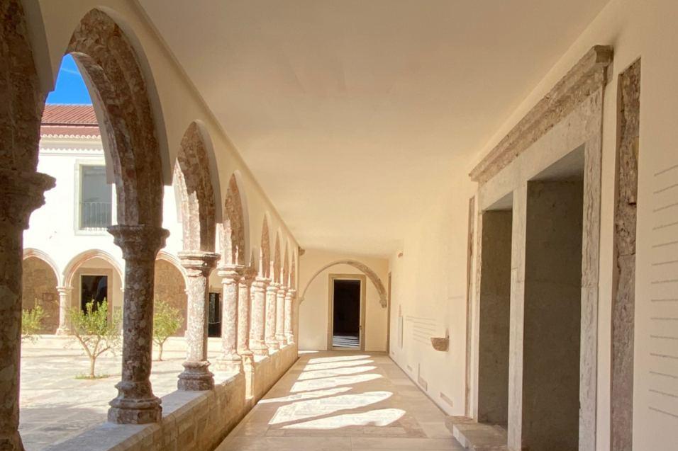 exterior arcade with stone arches and white walls
