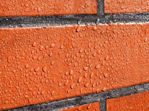Water droplets on a brick wall surface