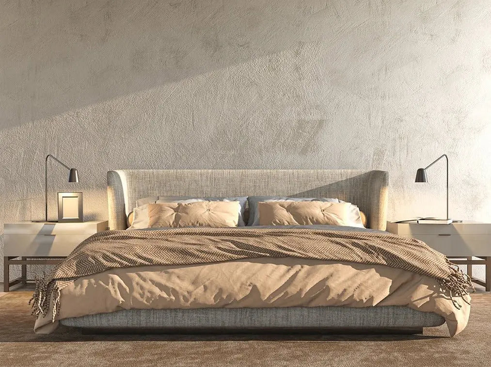 Modern bedroom with a large bed against a textured wall.