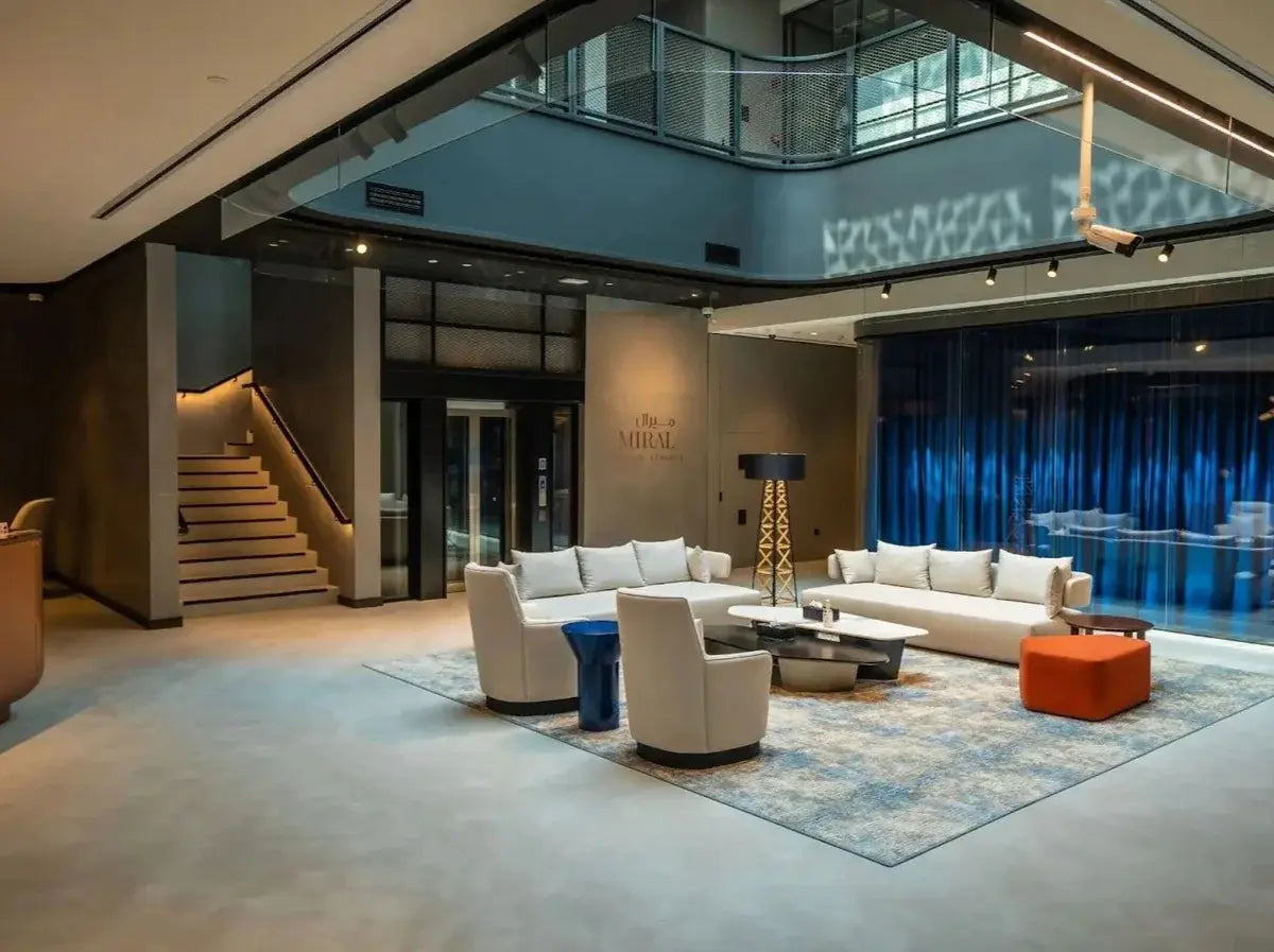 Modern interior of a building with a lounge area featuring microcement white sofas and chairs.