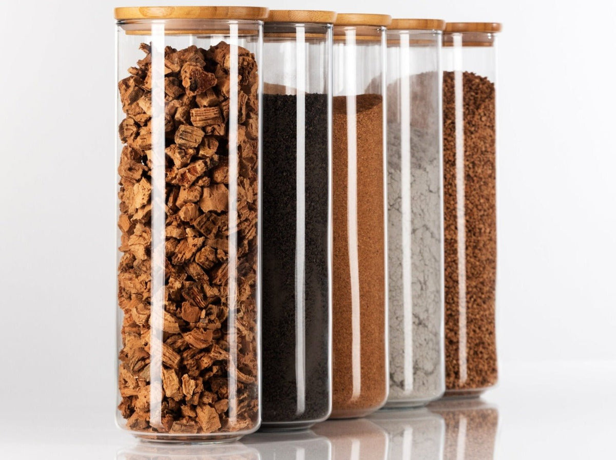 Glass beakers filled with cork granules, clay, lime