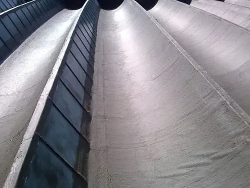 A close-up view of a water-based bituminous primer applied on a surface, showing a wet, shiny finish.